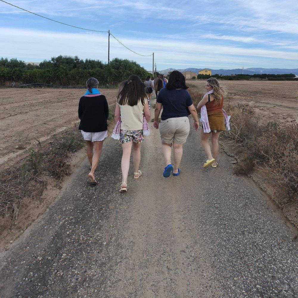 Grupo caminando junto a un caballo por un camino rural