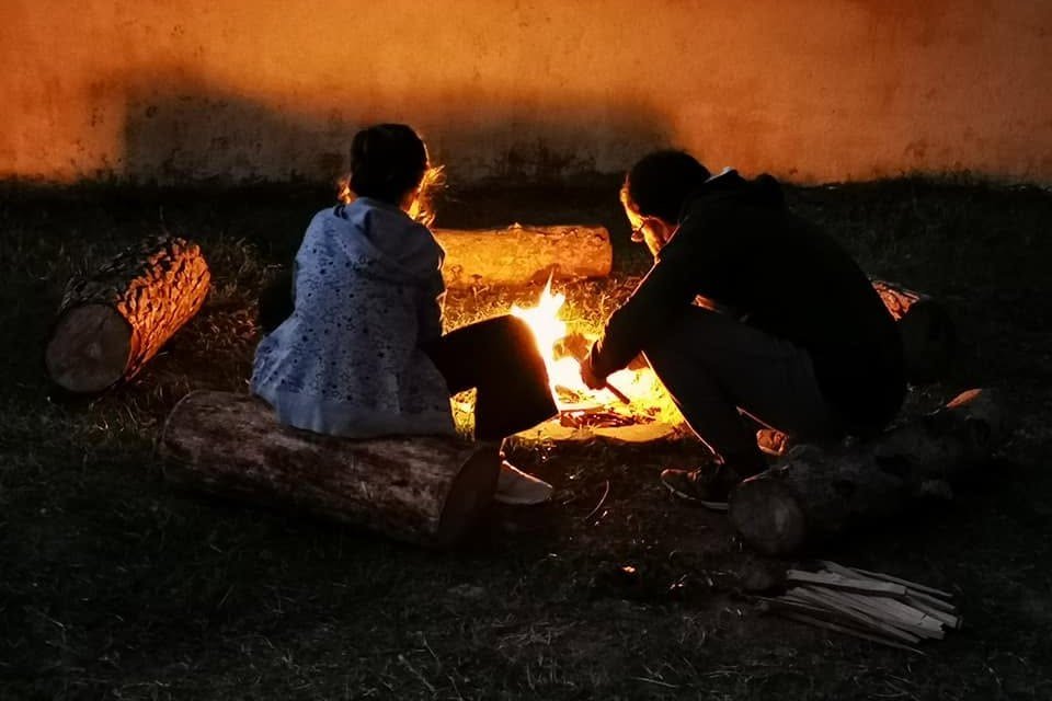 Dos personas junto al fuego, en un momento de acompañamiento cercano